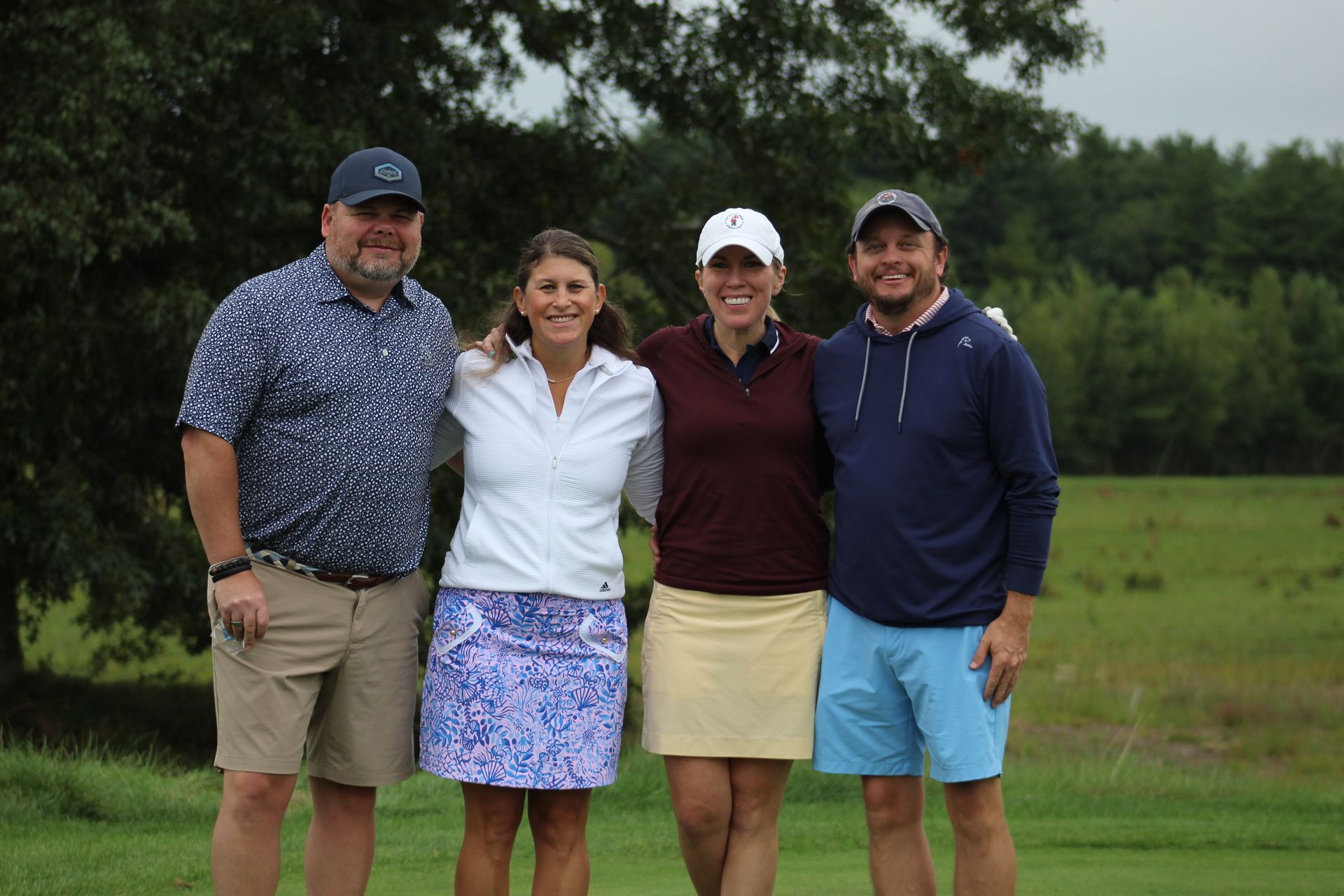 A group of people are posing for a picture on a golf course.