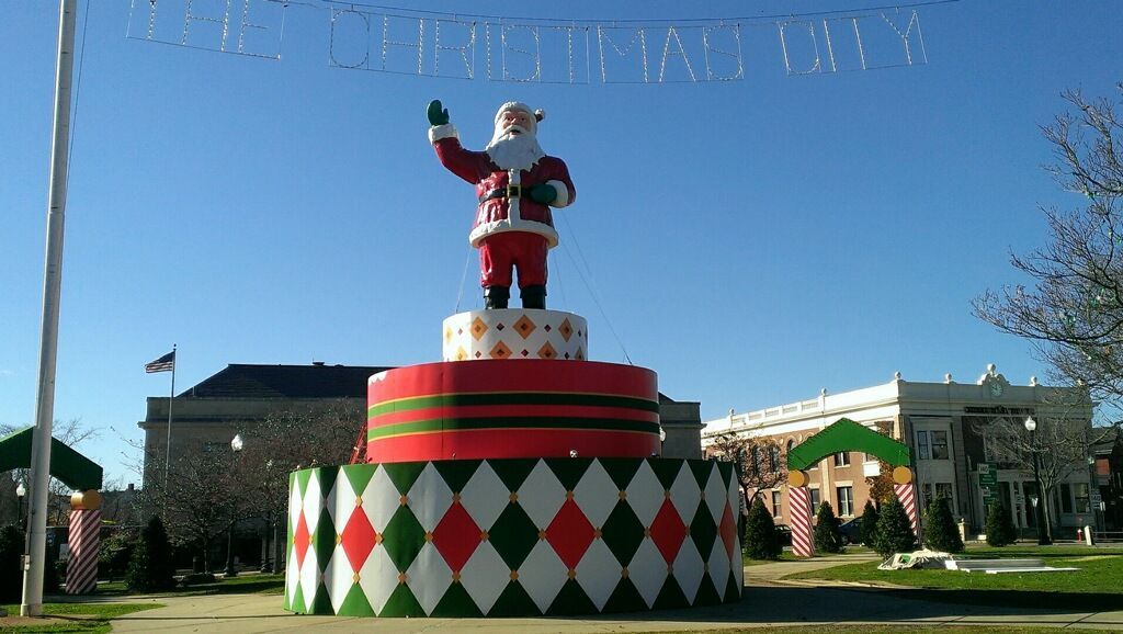A statue of Santa Claus is on top of a Christmas cake.