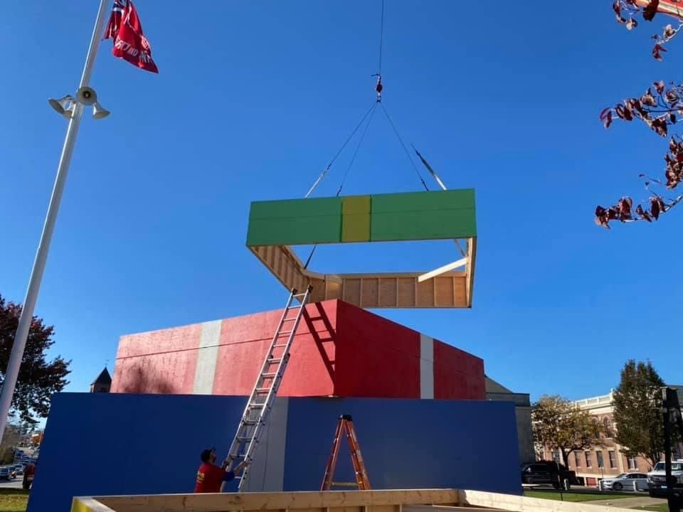 A crane is lifting a large piece of wood.