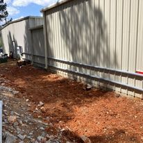 A white building with a lot of dirt in front of it.