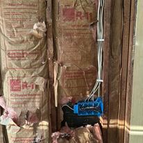 A bunch of insulation is sitting on a wooden wall.