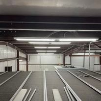 A large warehouse with a lot of lights on the ceiling.