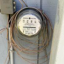 A close up of an electric meter with a bunch of wires attached to it.