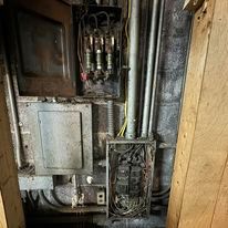 A very old electrical box with a lot of wires coming out of it.