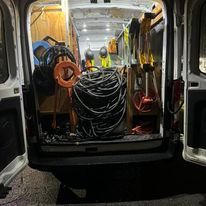 The back of a van is filled with lots of tools.