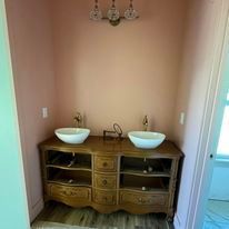 A bathroom with two sinks on a wooden vanity.
