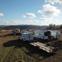 An aerial view of a group of vehicles parked in a field.