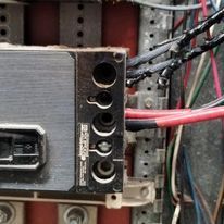 A close up of a electrical box with wires coming out of it.