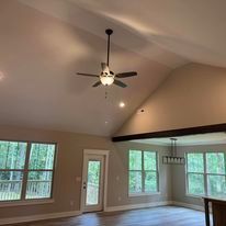 A living room with a vaulted ceiling and a ceiling fan.