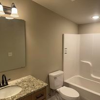 A bathroom with a toilet , sink and bathtub.