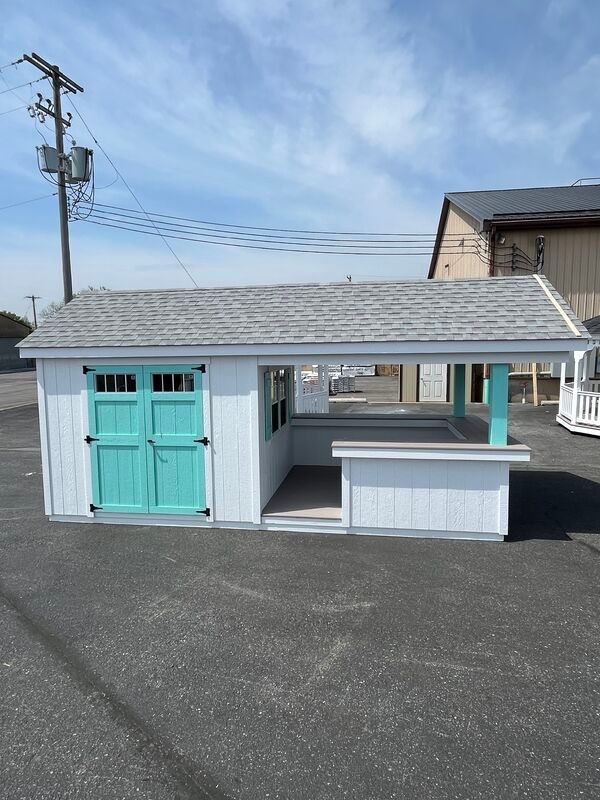 A white shed with blue doors and a gray roof