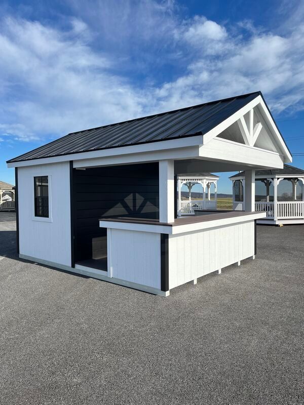 A white shed with a black roof and a bar on the side.