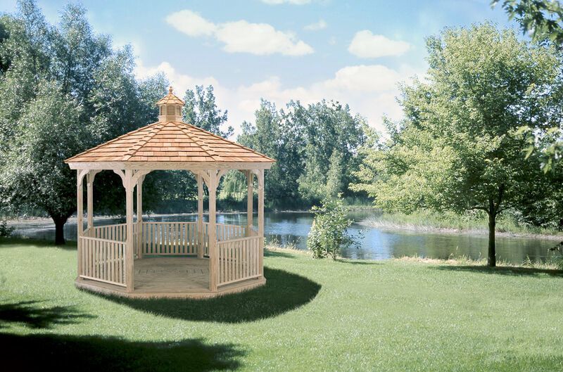 A gazebo is sitting in the middle of a lush green field.