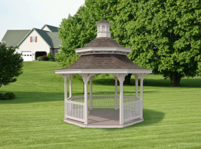 A white gazebo is sitting in the middle of a lush green field.