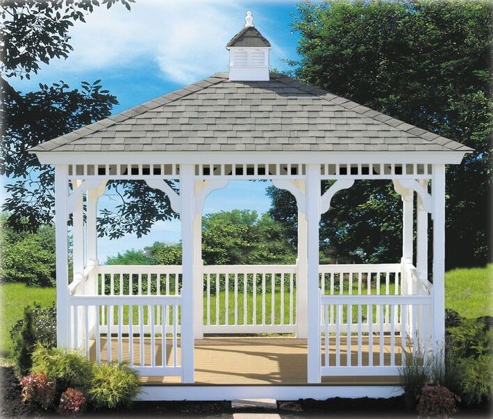 A white gazebo with a gray roof sits in the middle of a grassy field