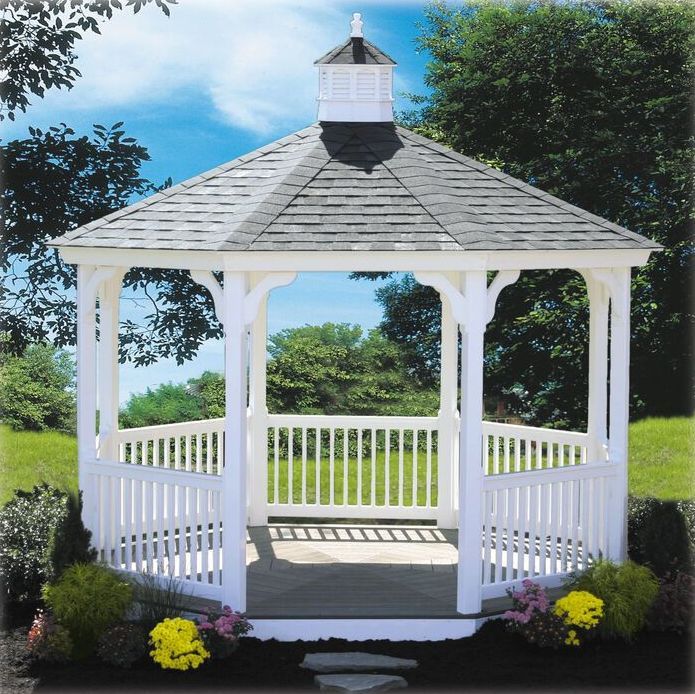 A white gazebo with a gray roof is surrounded by flowers
