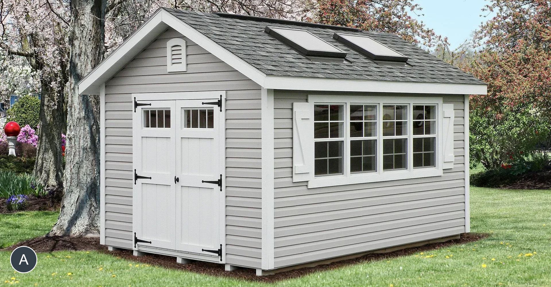 Light gray garden shed with a window, double doors, and a vent, set on grass.