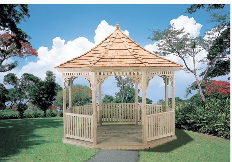 A wooden gazebo in a park with trees in the background