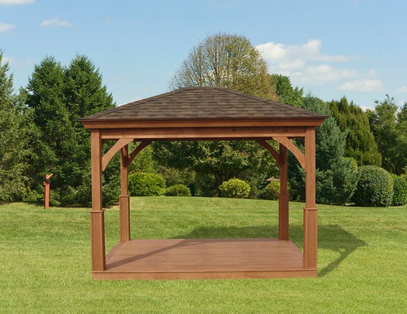 A wooden gazebo is sitting in the middle of a lush green field.