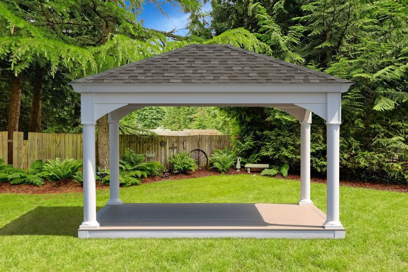 A white gazebo with a black roof is sitting on top of a lush green lawn.