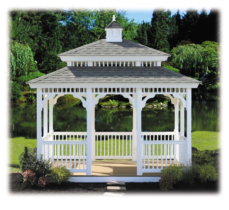 A white gazebo with a gray roof sits in the middle of a lush green field