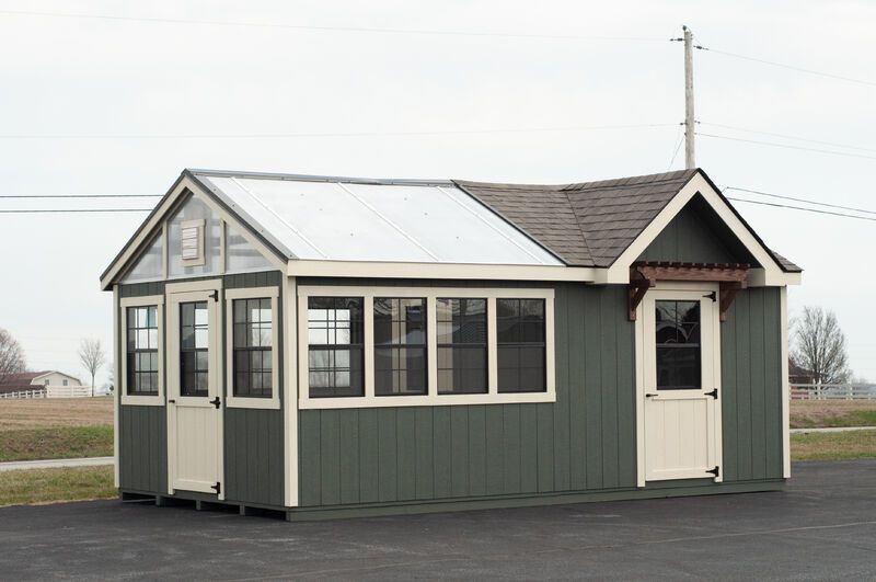 A small shed with a greenhouse attached to it