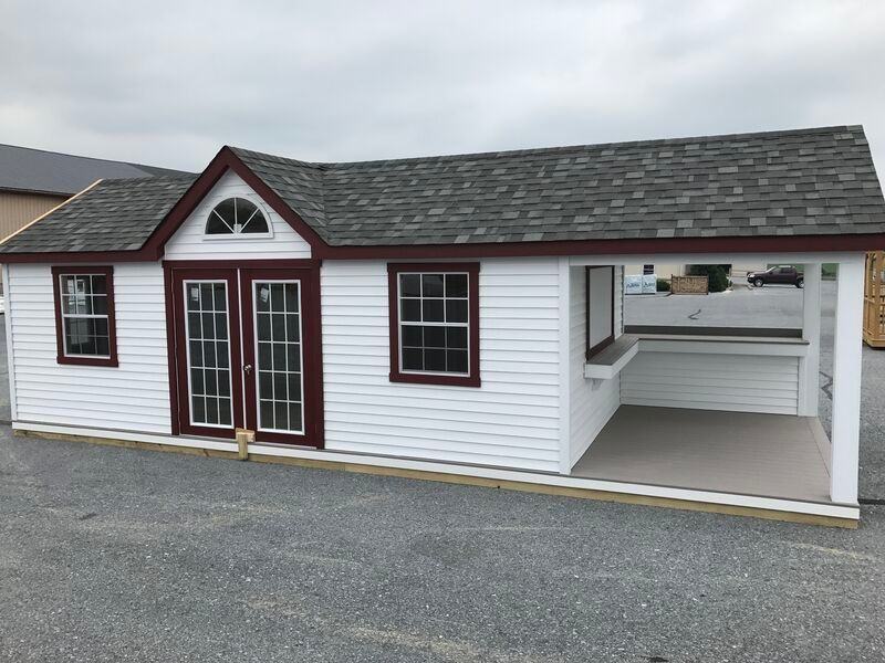A small white house with a gray roof and red trim.