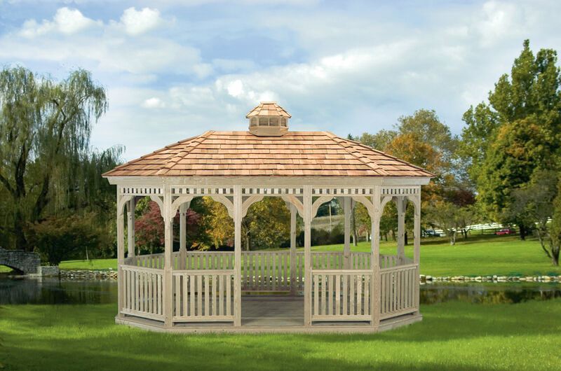 A white gazebo with a wooden roof is sitting on top of a lush green field.
