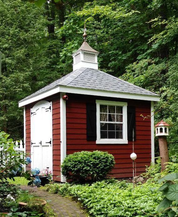 A red shed with a white roof and shutters