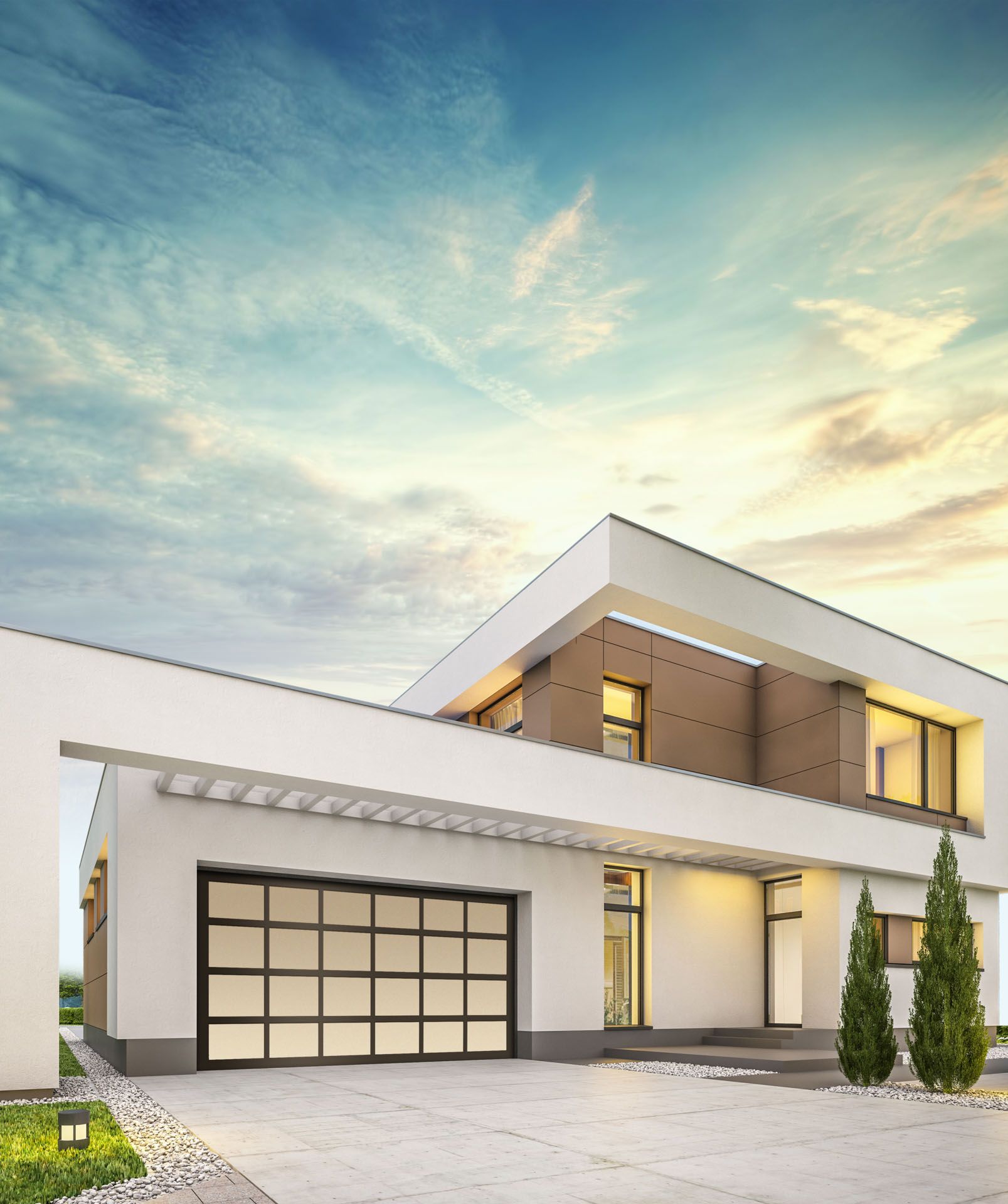 A modern house with a large garage door and a blue sky in the background.