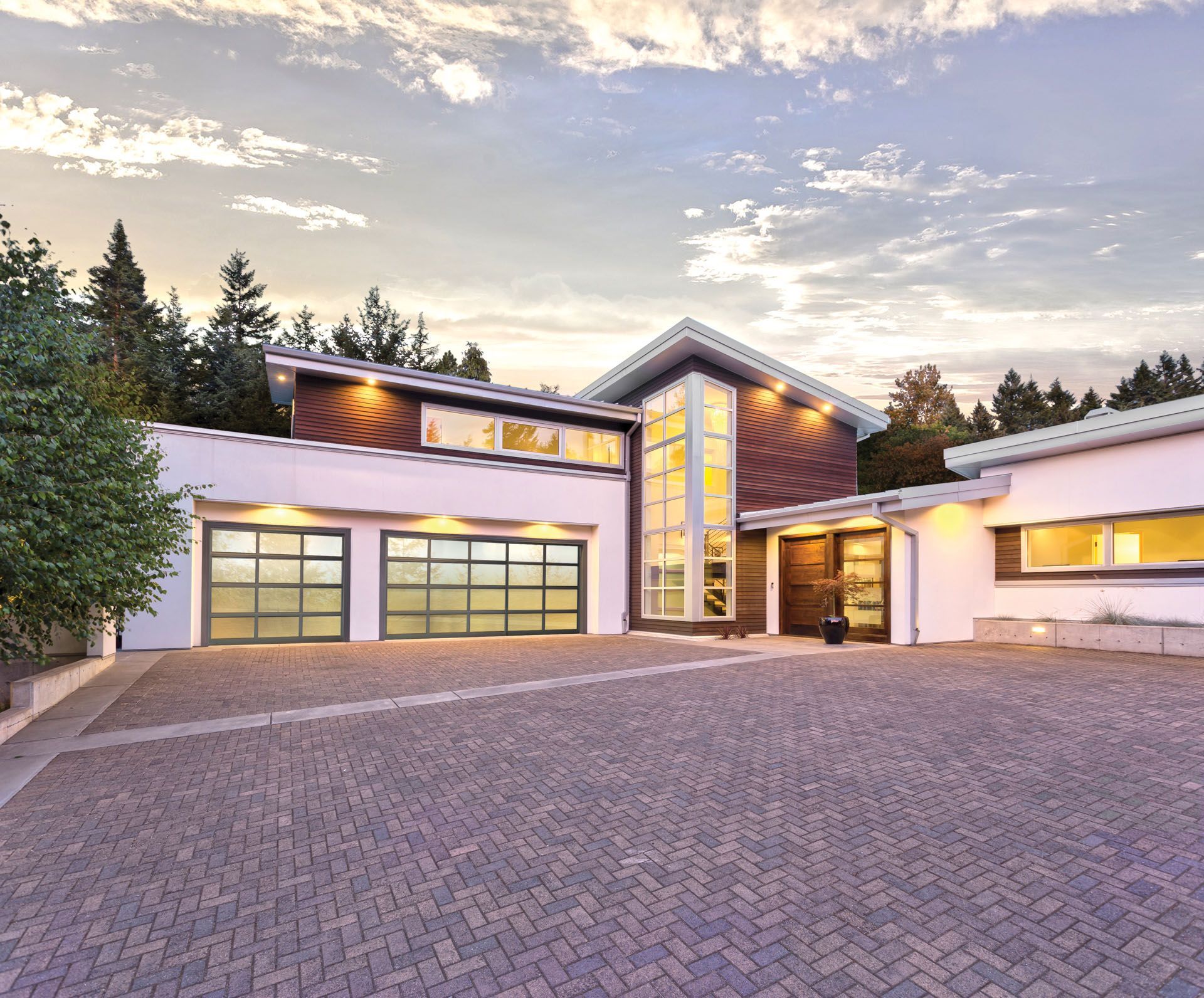 A large white house with a brick driveway in front of it