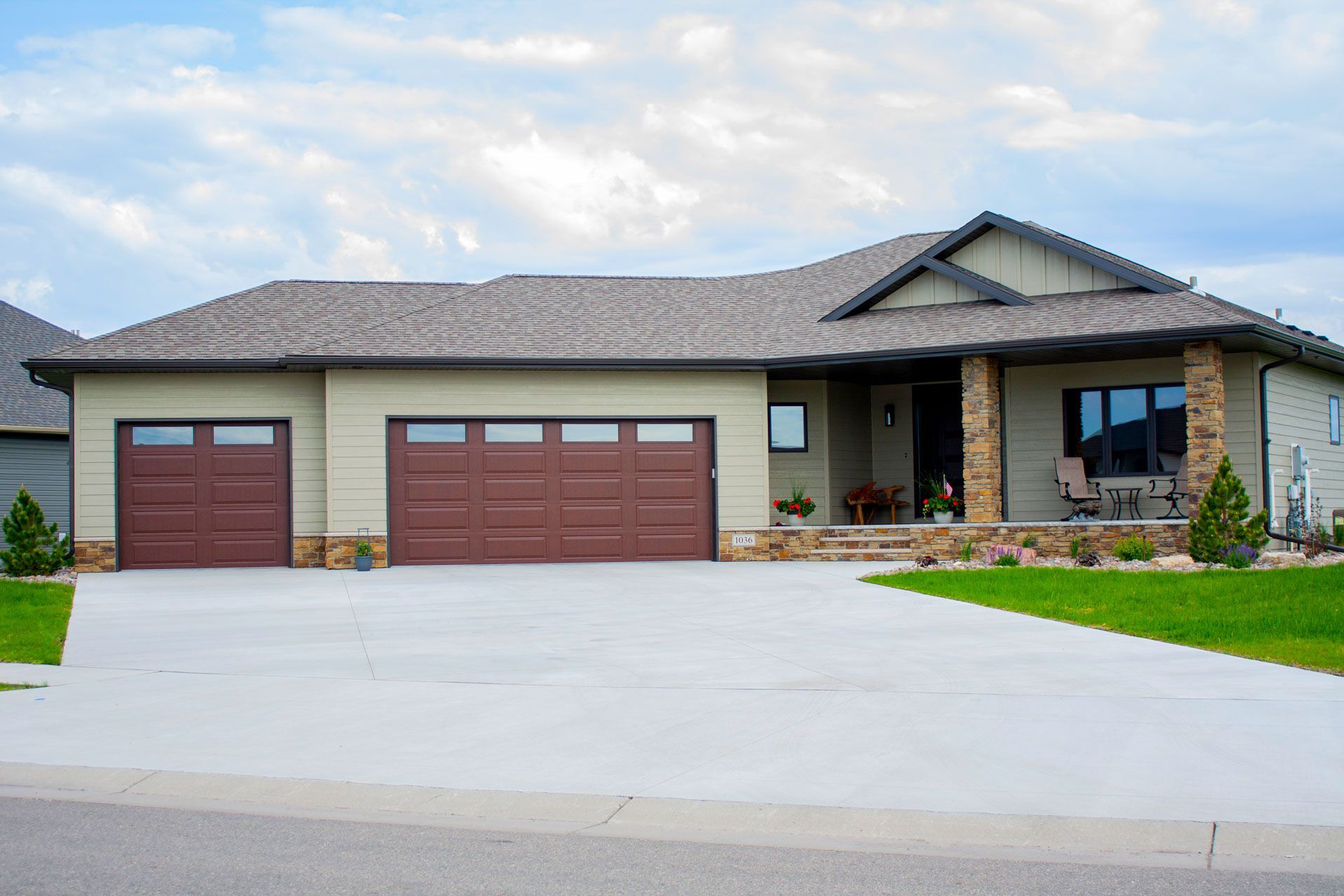 A large house with two garage doors and a large driveway.