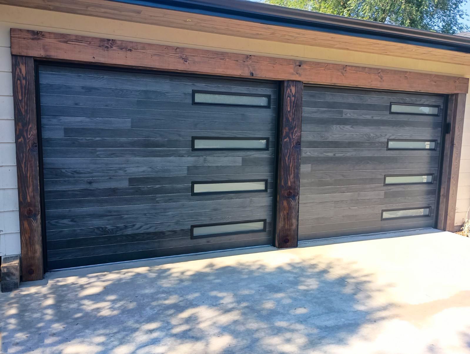 A garage door with a wooden finish and a wooden frame.