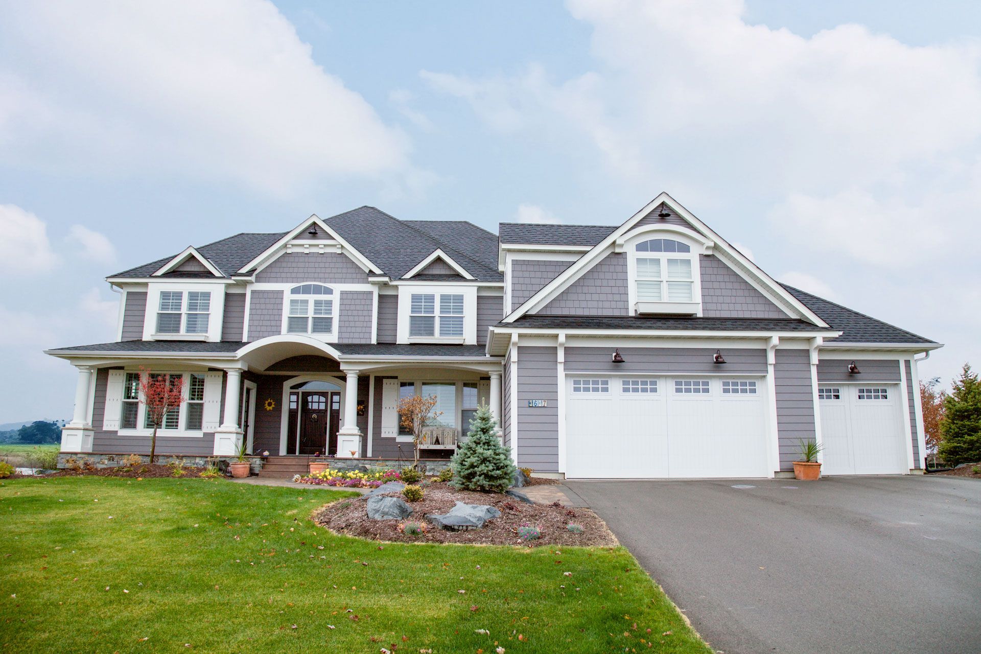A large house with a lot of windows and a driveway.