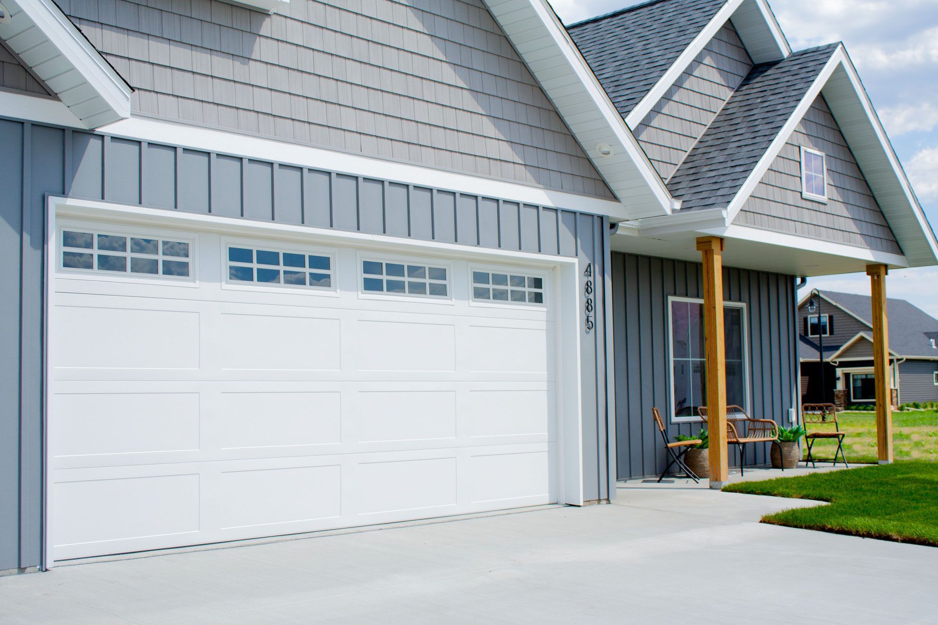 A house with a white garage door and a gray siding.