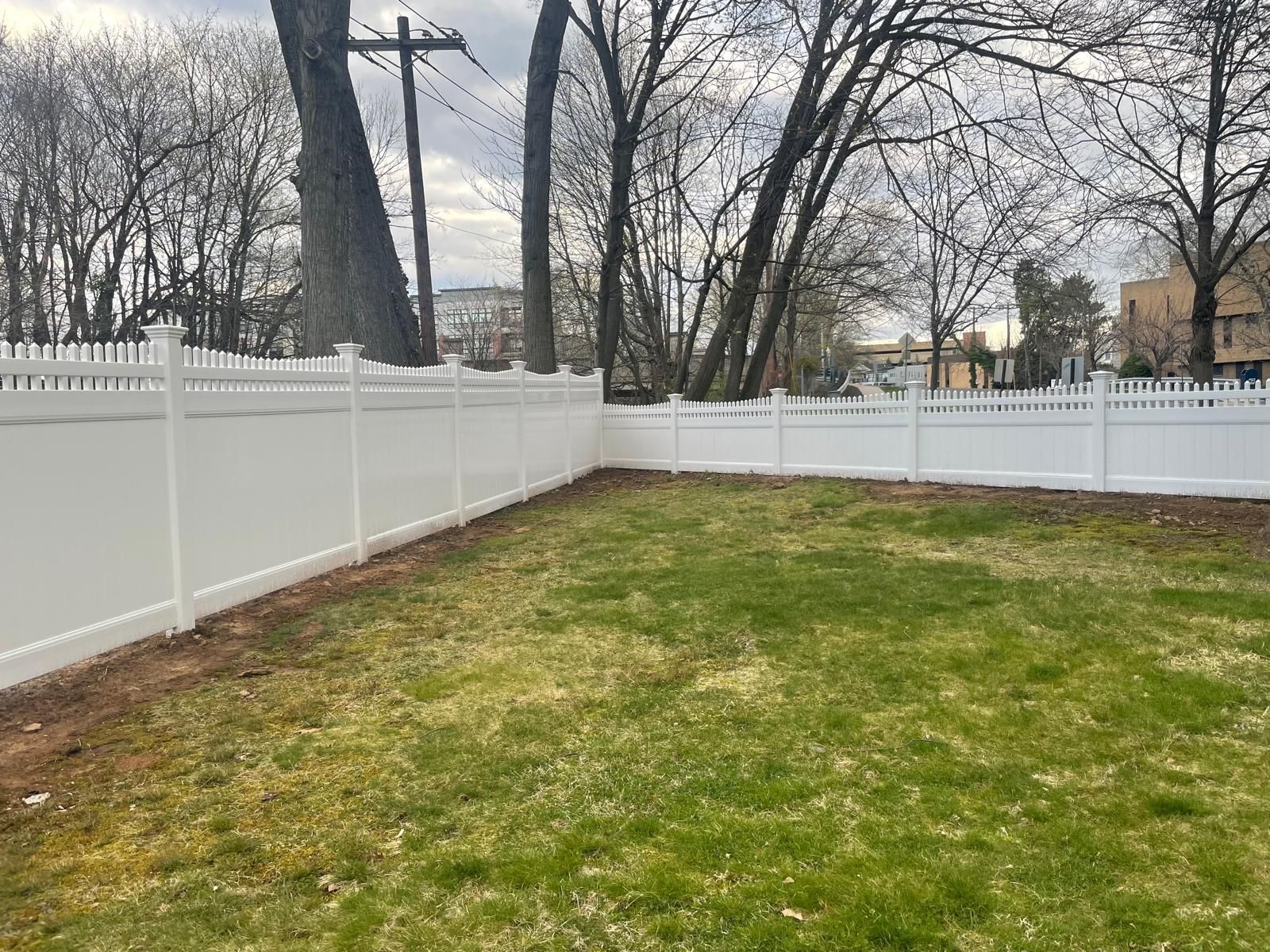A white picket fence surrounds a lush green yard.