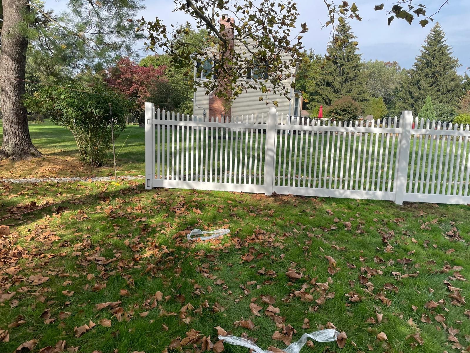 A white picket fence surrounds a lush green yard.