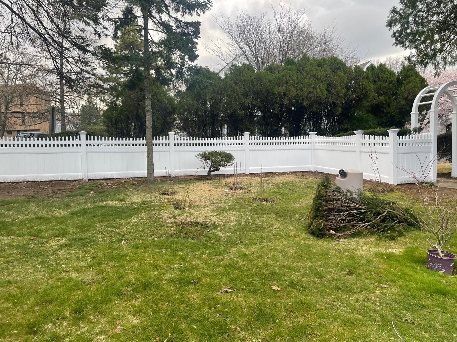 A white fence surrounds a lush green yard.