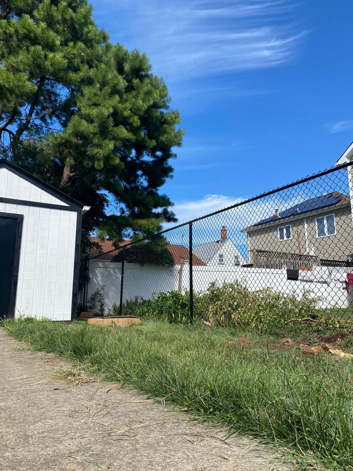 There is a chain link fence in the backyard of a house.