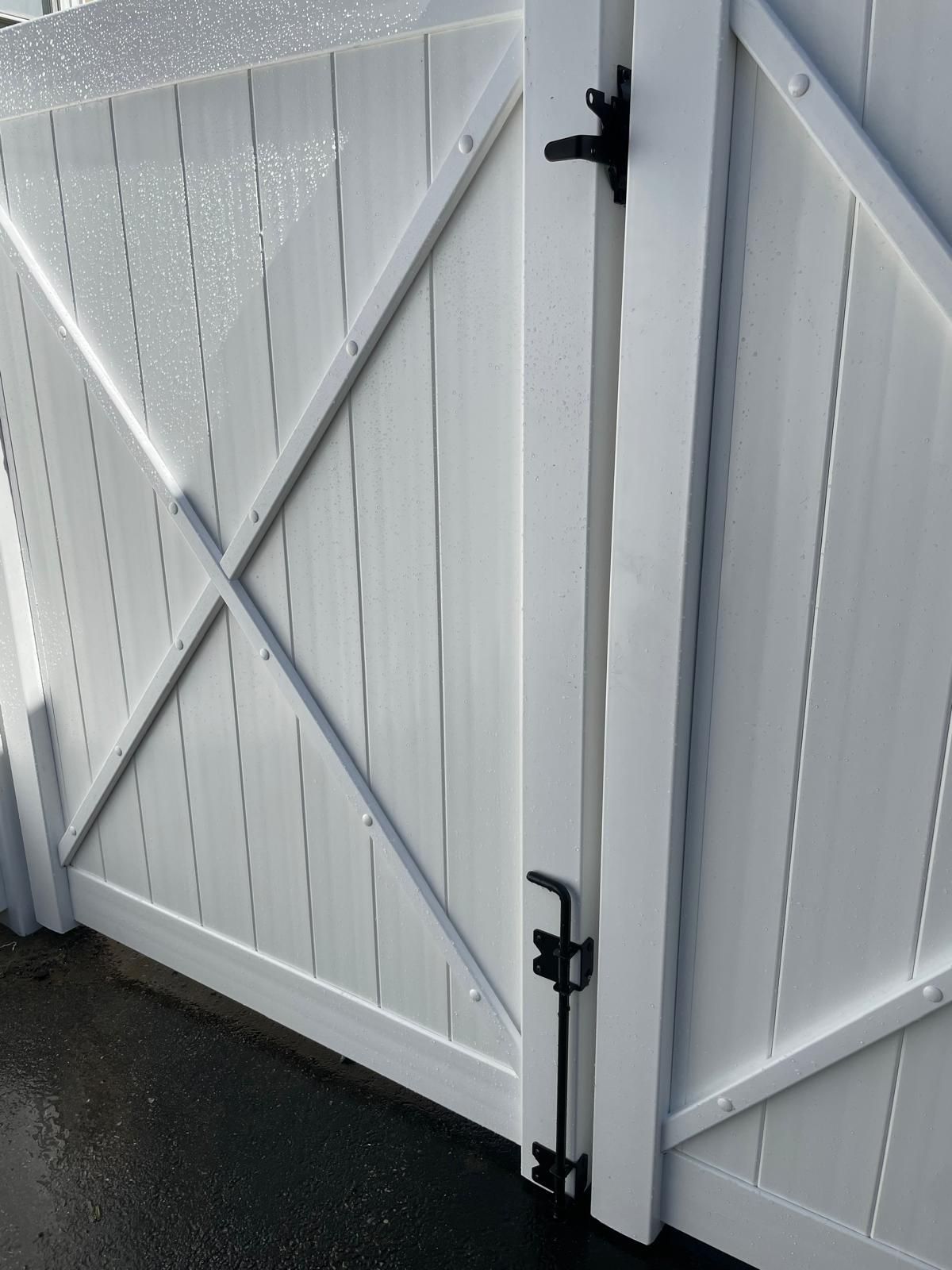 A white wooden gate with a black latch on it