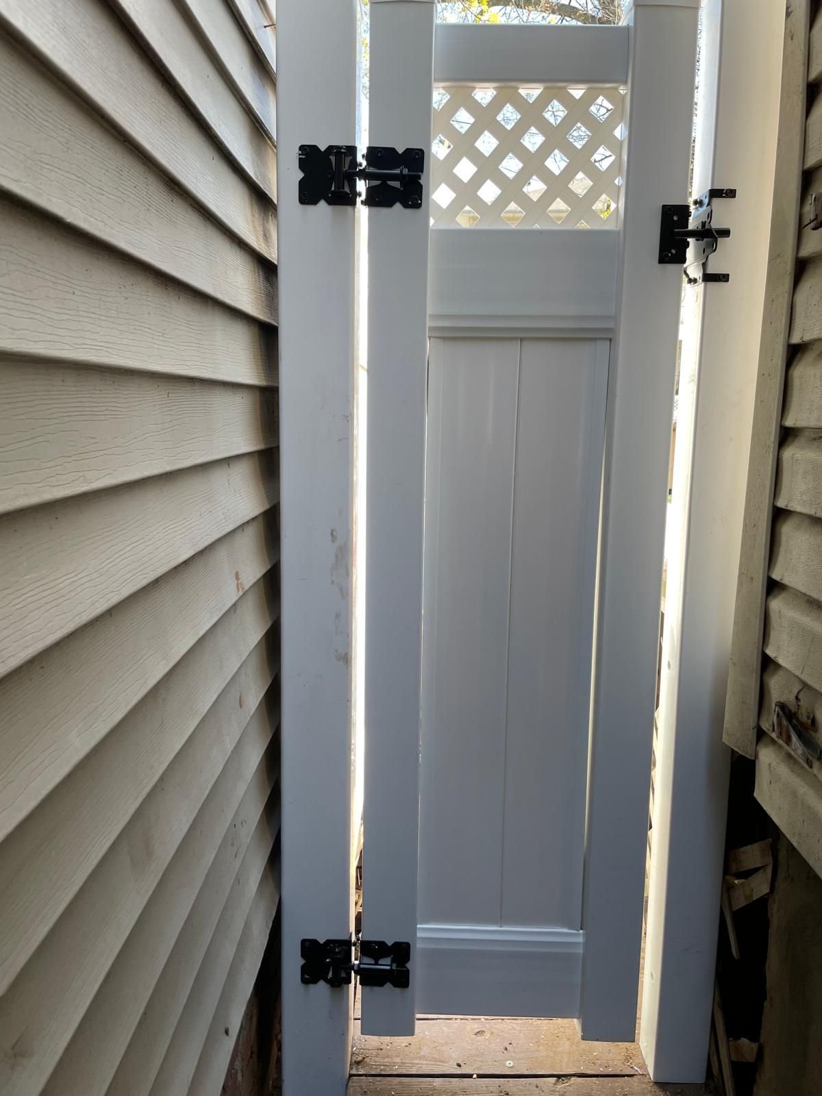 A white door with black hinges is between two houses