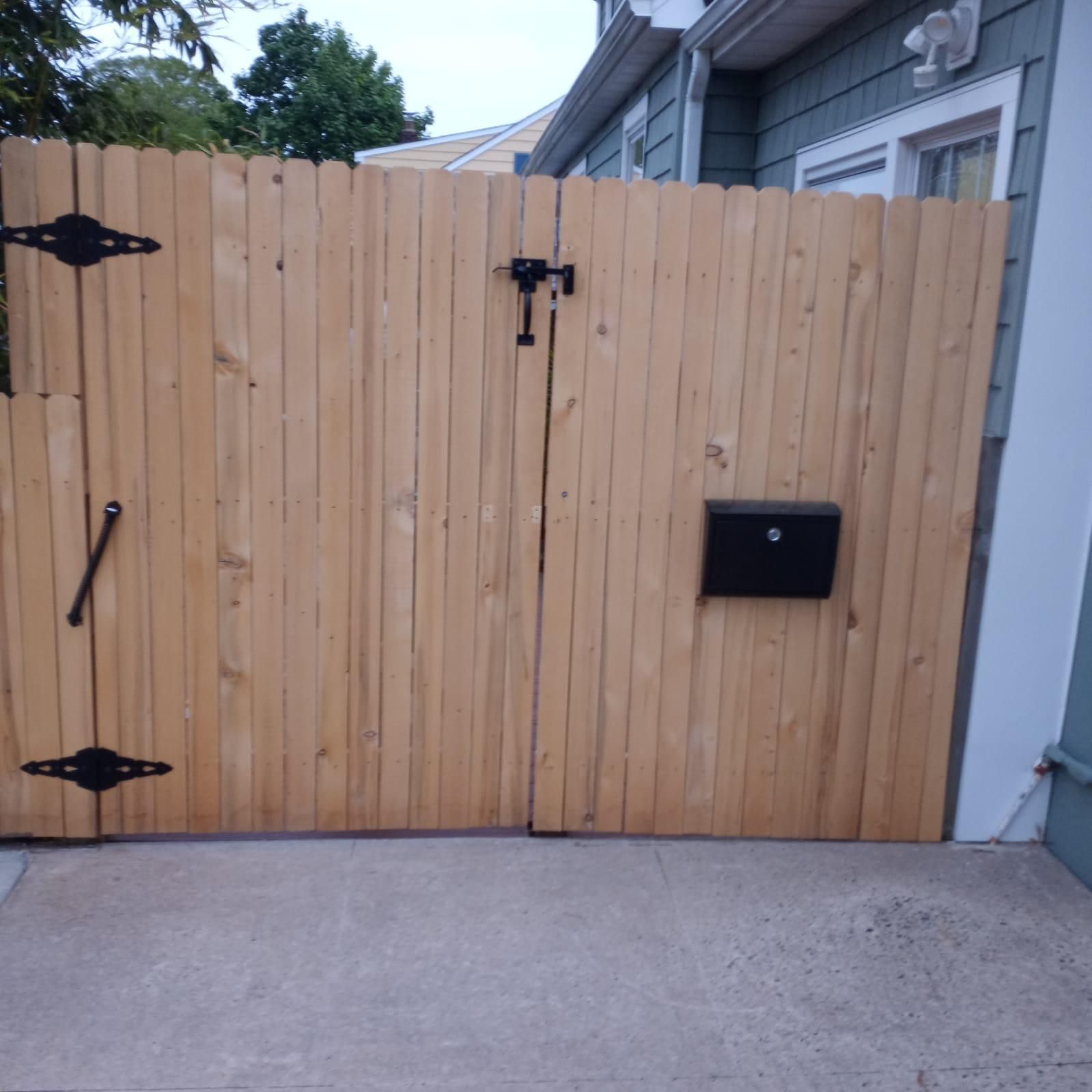 A wooden fence with a mailbox in front of it