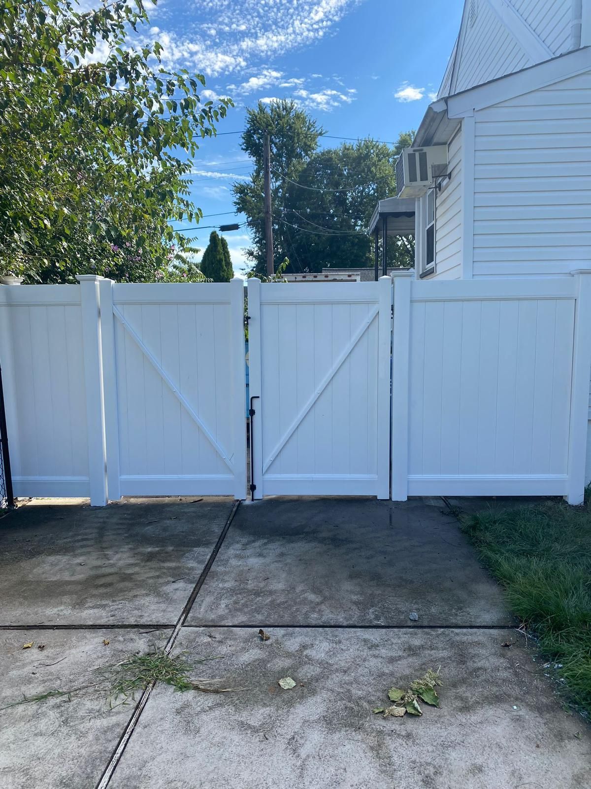 A white fence with a gate in front of a house.