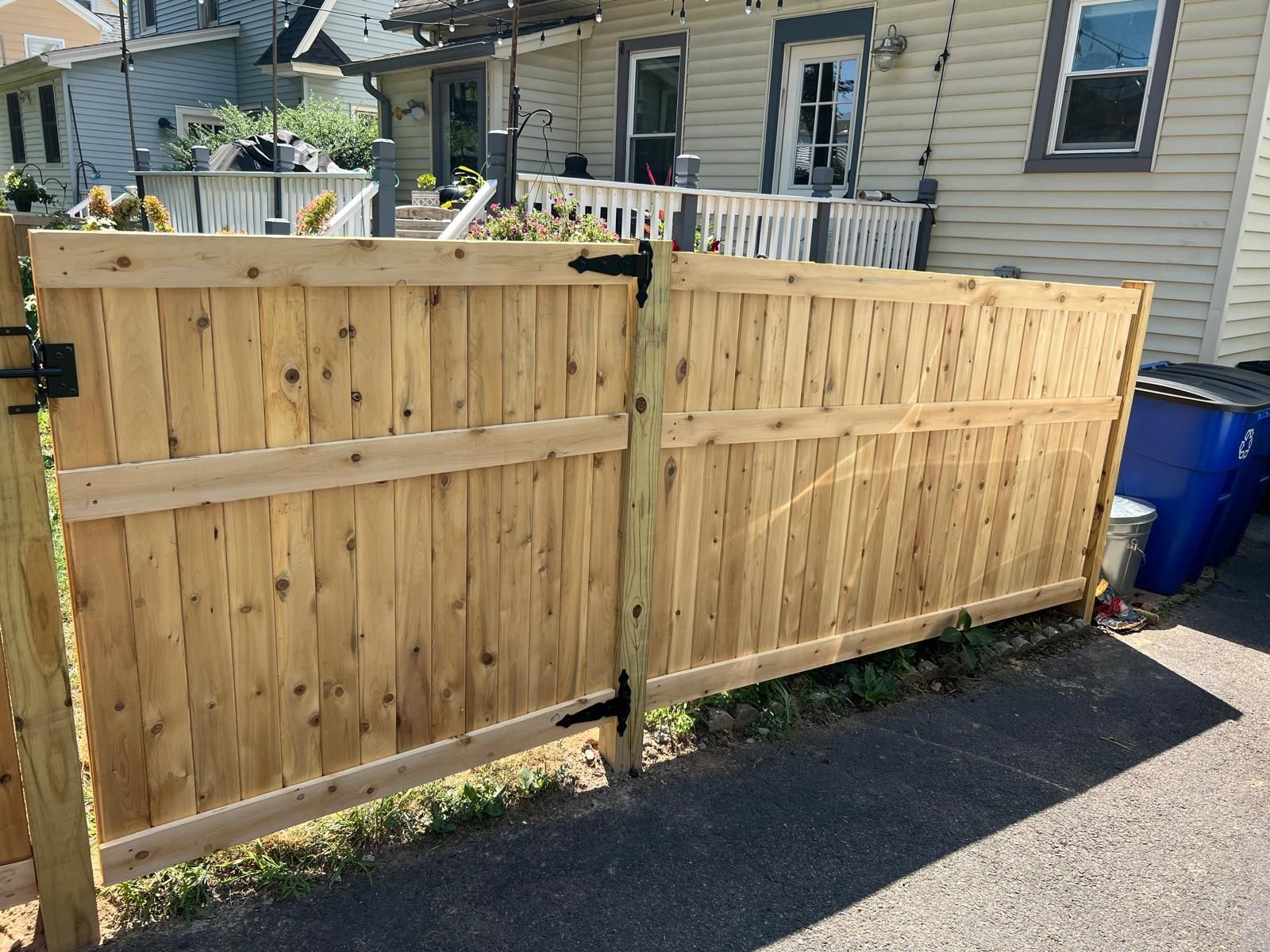 A wooden fence is sitting in front of a house.