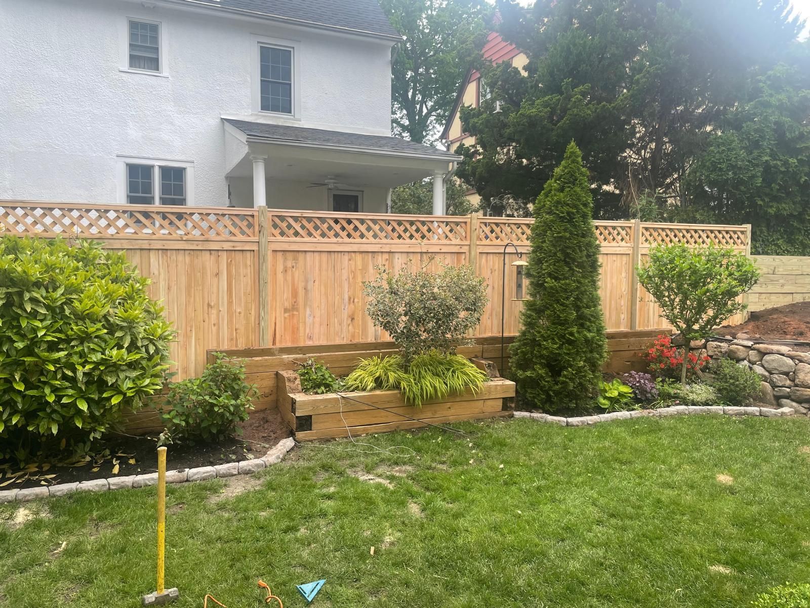 There is a wooden fence in the backyard of a house.