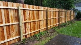 A wooden fence next to a grassy field
