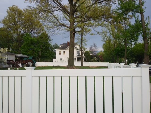 A white fence with a house in the background