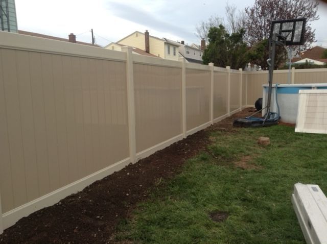 A fence with a basketball hoop in the backyard
