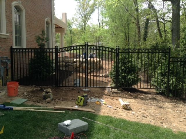A fence is being built in the backyard of a house.