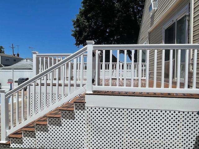 Stairs leading up to a deck with a white railing